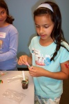 A young wormologist stirs up some "dirt dessert" - a concoction of chocolate pudding, milk and gummy worms.