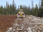 Ripping of the frozen pad material so it can be spread evenly over the site contours
